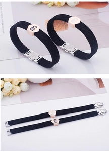 Detail of black silicone sports bracelet featuring rose gold hexagon charms and metal buckle