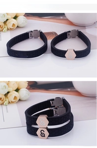 Detail of black silicone energy bracelet featuring honeycomb texture and rose gold hexagon