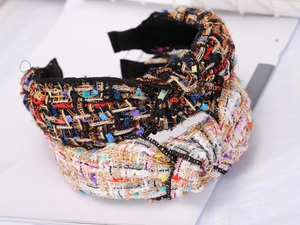 Close-up of wide tweed headbands featuring multi-color woven texture and knotted design