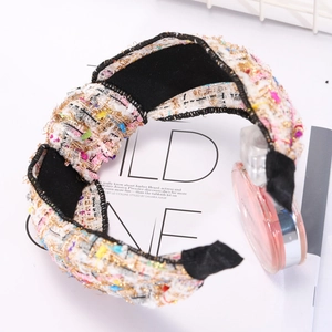 Close-up of wide knotted headband in colorful tweed fabric with elegant textured finish