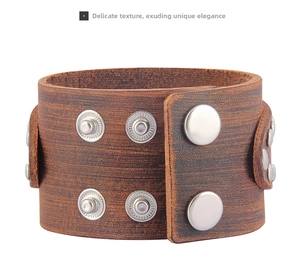 Detail view of the brown leather texture and silver metal snap fasteners on the punk bracelet