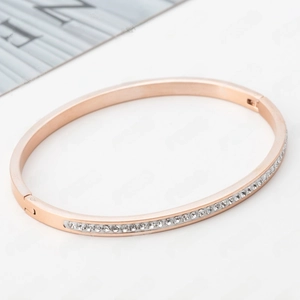 Detail of rose gold stainless steel bangle featuring single row clear zircon channel setting