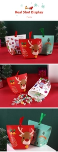 Detail shot of Christmas gift bags with festive reindeer patterns and satin ribbon handles