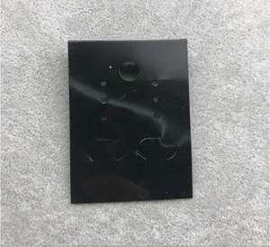Detail of a black PVC jewelry display card with Fashion Jewelry branding on grey fabric