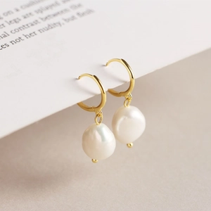 Macro shot of S925 silver golden hoop earrings with natural baroque freshwater pearls