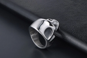 Macro shot of silver skull ring showing detailed brushed stainless steel texture