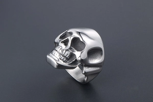 Macro shot of silver skull ring detail showing polished stainless steel punk texture