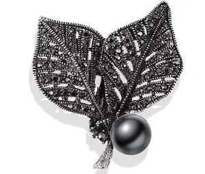 Vintage gun-black leaf brooch with black rhinestones and a large dark pearl
