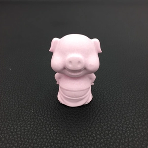 Front view of a matte pink piglet statue on a black textured surface for home decor