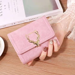 Close-up of pink frosted leather wallet with golden deer charm held by a person
