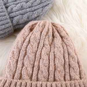 Macro shot of pink and gray cable knit beanies showing thick mohair texture