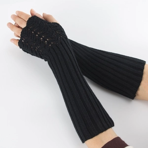 Detail of black knit fingerless gloves showing wave patterns and thumb hole texture