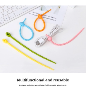 Set of colorful silicone cable ties organizing a white USB data cable on a clean desk.