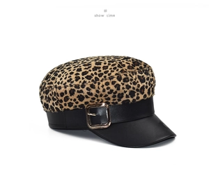 Detail of leopard print wool newsboy hat with black leather brim and golden metal buckle