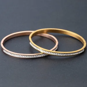 Detail of rose gold and gold 4mm open bangles with a single row of white zircon inlay