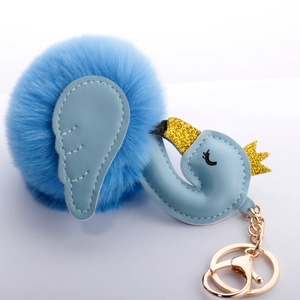 Close-up of light blue plush swan keychain with golden crown and metal lobster clasp