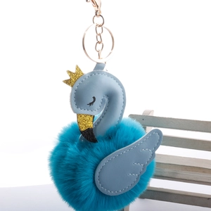 Detail of blue plush flamingo keychain with gold crown and metallic lobster clasp