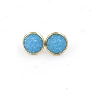 Detail view of 12mm gold-plated stud earrings with light blue resin druzy stone texture