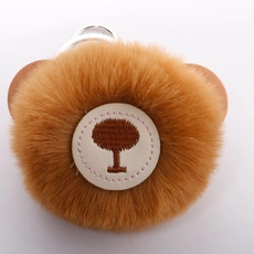 Detailed view of brown plush faux fur heart keychain with bear ears and tree logo charm
