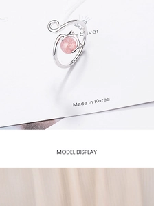 Detailed view of silver cat ring with pink strawberry crystal on a model display