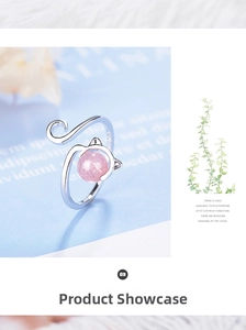 Detailed close-up of a cat-themed silver ring with a pink strawberry crystal gemstone