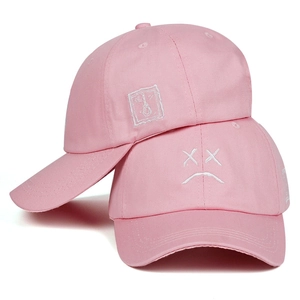 Pink cotton baseball cap with white sad face and knot embroidery in two-piece display