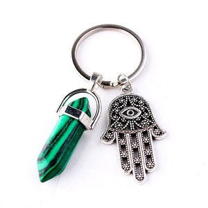 Green crystal pillar keychain with silver Hamsa Hand charm on white background
