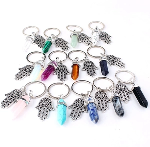 Detailed close-up of colorful natural crystal stone pendants and Hamsa hand keychains