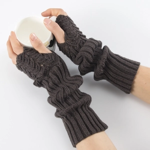 Close-up of coffee brown knitted fingerless gloves with ribbed texture holding a cup