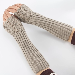 Detailed knit texture of long beige fingerless gloves with elegant wave pattern