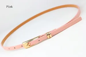 Slim pink women's waist belt with golden metal pin buckle on white textured fabric