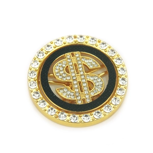 Golden dollar sign badge with sparkling rhinestones on a textured black background