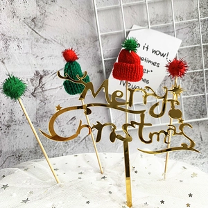 Detail of gold acrylic Merry Christmas topper with red and green mini knit hats