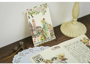 Retro vintage floral stickers and Victorian cards displayed on a dark wooden desk setup