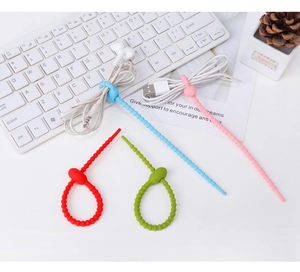 Vibrant colorful silicone cable ties shown organizing USB cables and headphones on desk