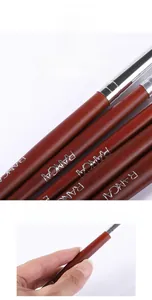 Detail of solid wood handle with silver ferrule and brand logo on makeup brush