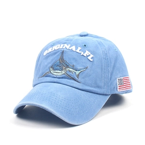 Detail of blue washed cotton baseball cap with shark embroidery and US flag patch