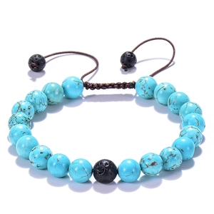 Adjustable woven bracelet with blue turquoise beads and black lava stones on white background