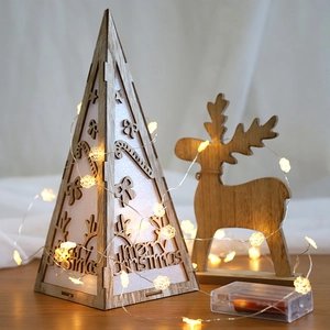 Wooden Christmas tree and reindeer decoration with warm LED fairy lights for holiday decor