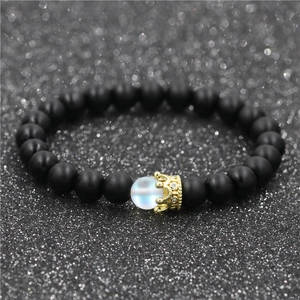 Close-up of beaded crown bracelet with matte black beads and iridescent moonstone accent