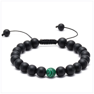 Detail of adjustable lava stone bracelet with green malachite accent on white backdrop