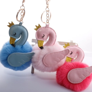 Detailed view of swan plush keychains in blue, pink, and rose red with glitter crowns