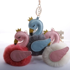 Three plush flamingo keychains with glitter crowns and soft faux fur pompom details