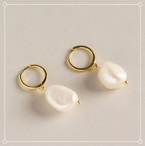 Detailed macro view of S925 silver hoop earrings with baroque irregular freshwater pearls