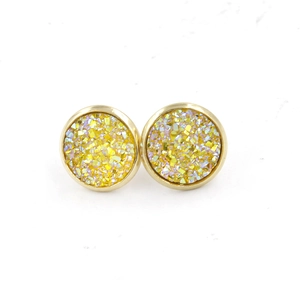 Macro detail of 12mm gold plated stud earrings with yellow druzy resin texture