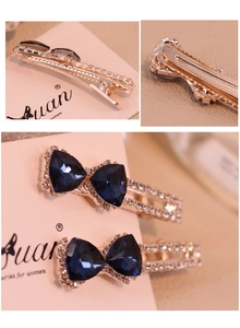 Détail de la pince à cheveux nœud en cristal bleu foncé avec finition dorée et strass