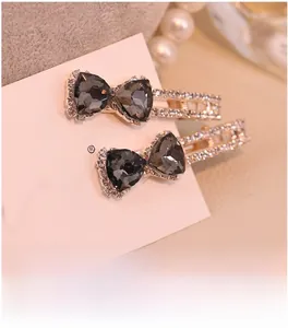 Gros plan de barrettes noeud en strass avec gemmes grises sur carte blanche