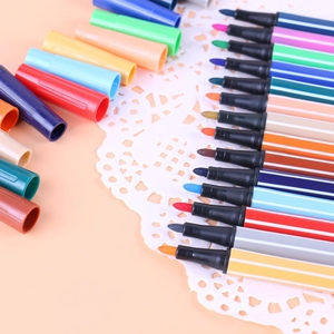 Vista plana de rotuladores de acuarela de colores sobre papel de encaje con tapas