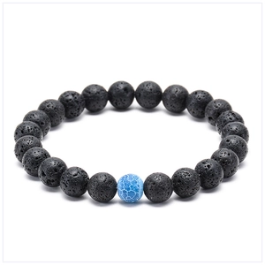 Detailed close-up of black lava rock bracelet with a blue crackle bead on white background
