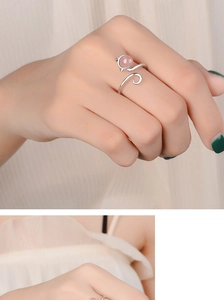 Detail of silver cat ring with pink strawberry crystal on model's finger